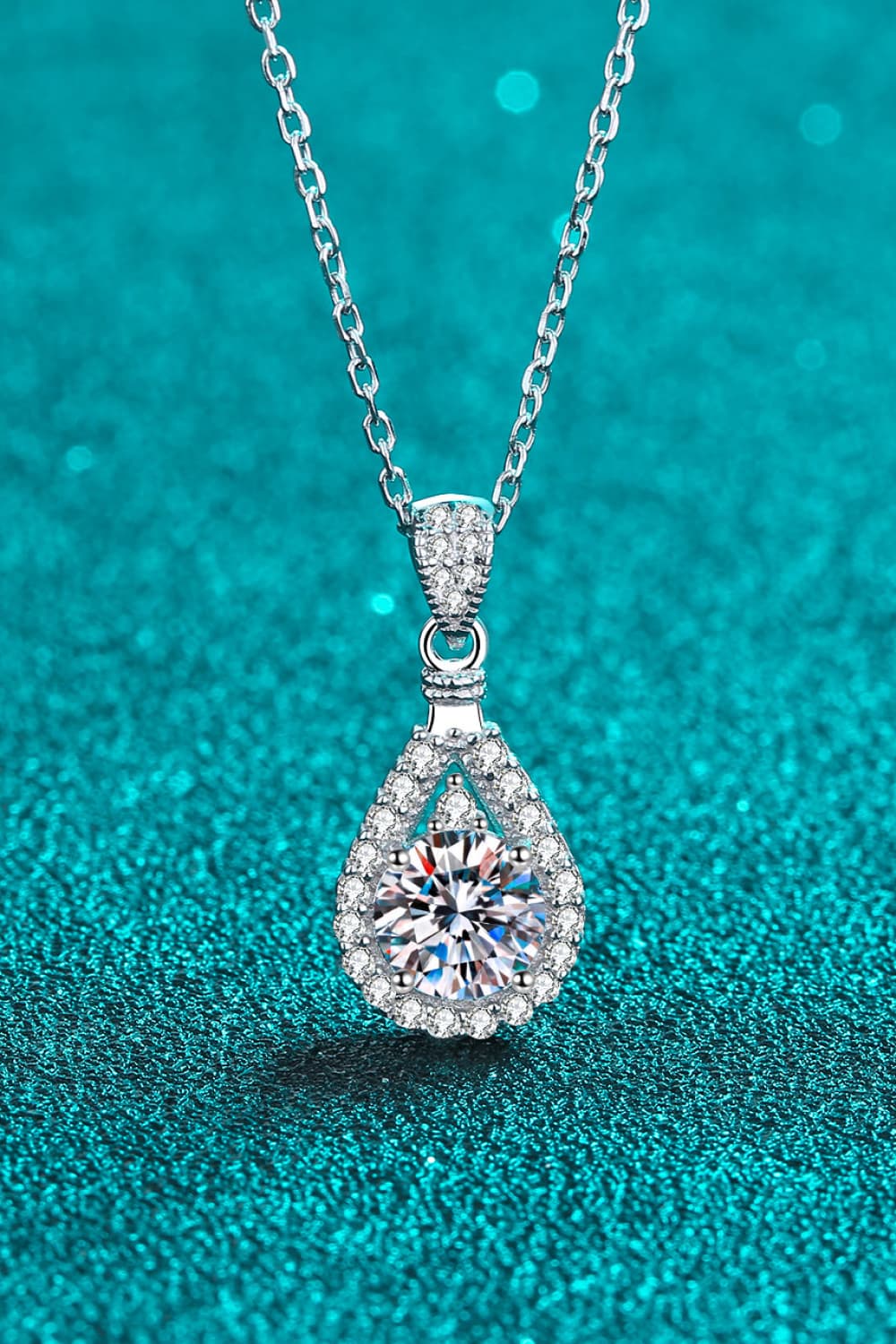 "Minimalist Moissanite pendant made with 925 sterling silver and rhodium-plated, featuring a 2-carat Moissanite stone. Includes a certificate of stone properties, matching box, and has a 16-inch chain with a 2-inch extension."