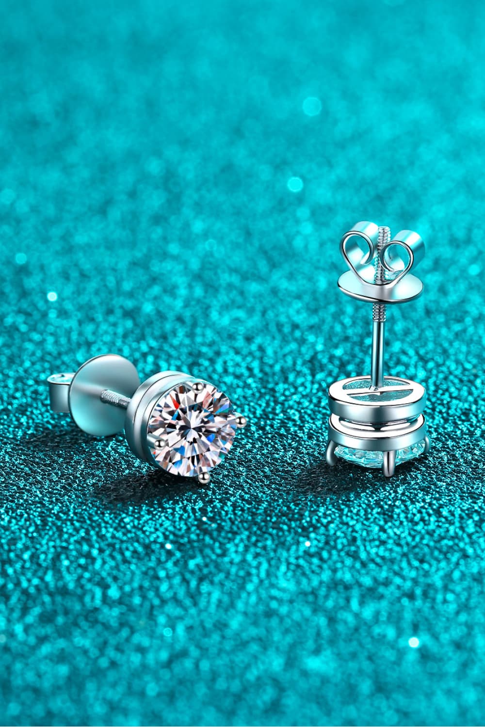 "Minimalist Moissanite stud earrings made with 925 sterling silver, rhodium-plated, featuring 1 carat Moissanite stones in each earring for a total of 2 carats. Includes a certificate of stone properties and comes with a matching box."