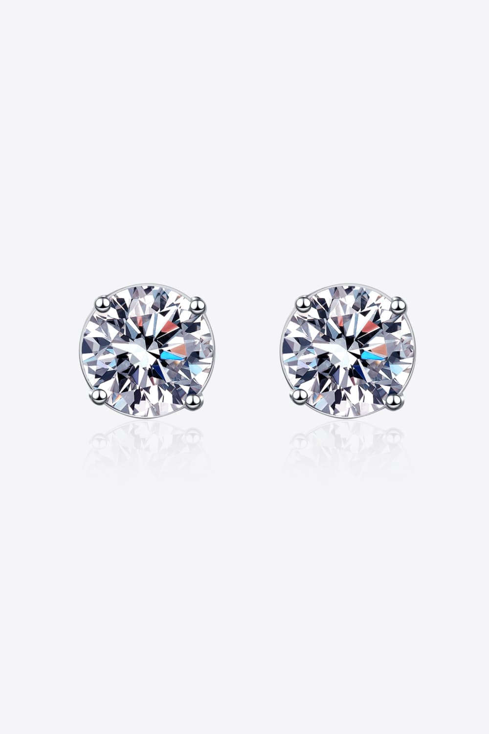 "Minimalist Moissanite stud earrings made with 925 sterling silver, rhodium-plated, featuring 1 carat Moissanite stones in each earring for a total of 2 carats. Includes a certificate of stone properties and comes with a matching box."